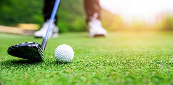 Close up golf ball on green grass field. sport golf club