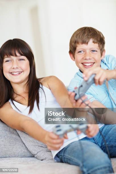 Piccolo Ragazzo E Ragazza Giocare Videogiochi E A Casa - Fotografie stock e altre immagini di 12-13 anni