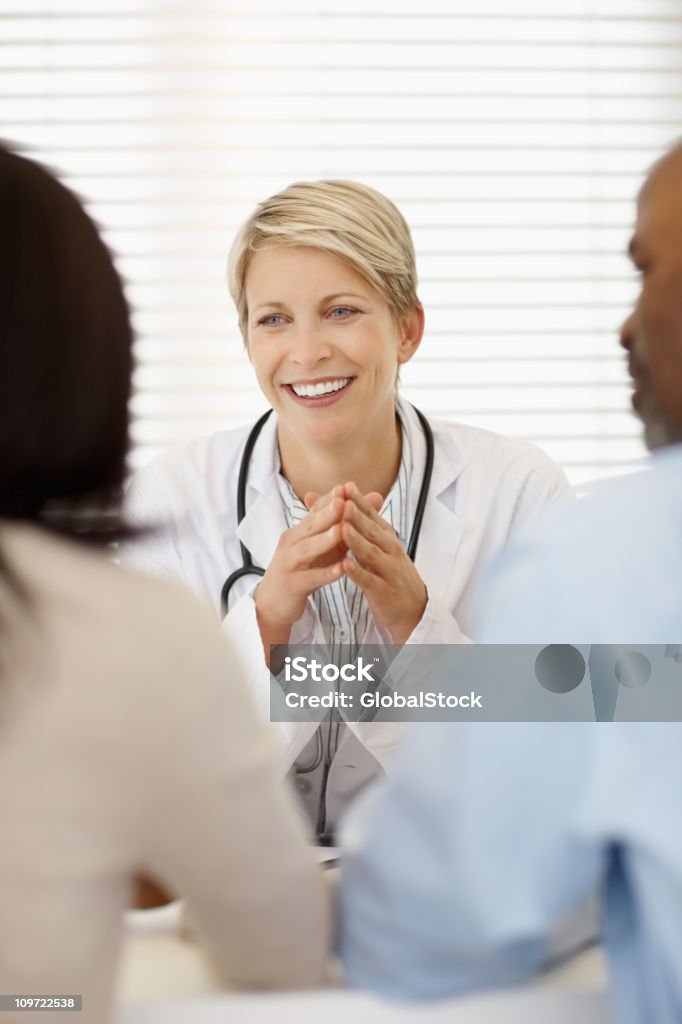 Femmina medico in discussione con un paio di - Foto stock royalty-free di 35-39 anni