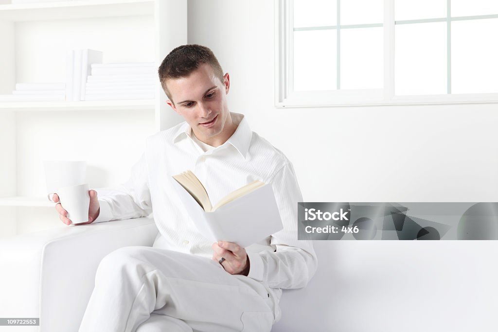 Homem ler um livro e beber café - Royalty-free Pernas Cruzadas Foto de stock