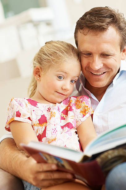 istock Father and daughter reading a story book together 109722605