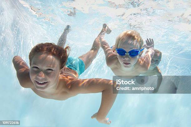 Boys In Swimming Pool Underwater Stock Photo - Download Image Now - Swimming, Activity, Blue