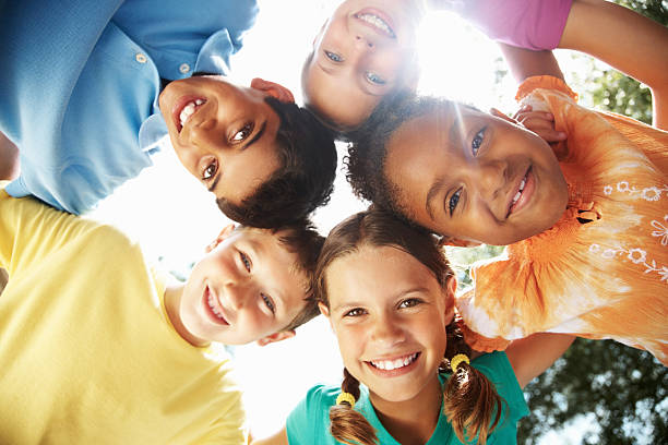 multirracial jovens amigos fazendo uma reunião contra o céu - clothing image type childhood nature - fotografias e filmes do acervo