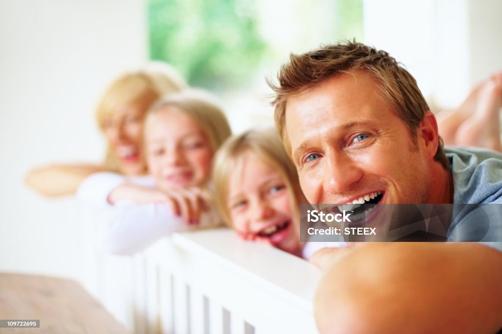 Cheerful man lying in bed with his family  20-29 Years Stock Photo