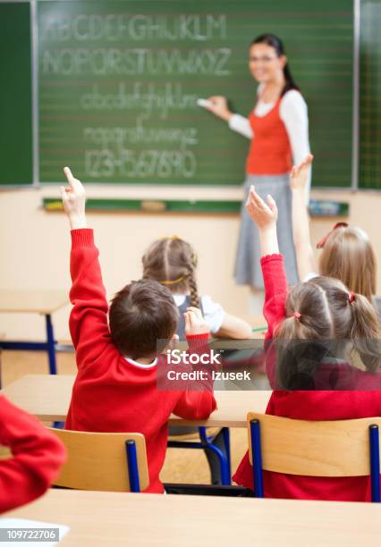 Elementary School Children Raising Hands In Class Rear View Stock Photo - Download Image Now