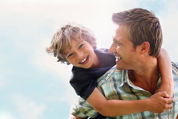 istock Playful father giving his son piggy back ride against sky 109722726