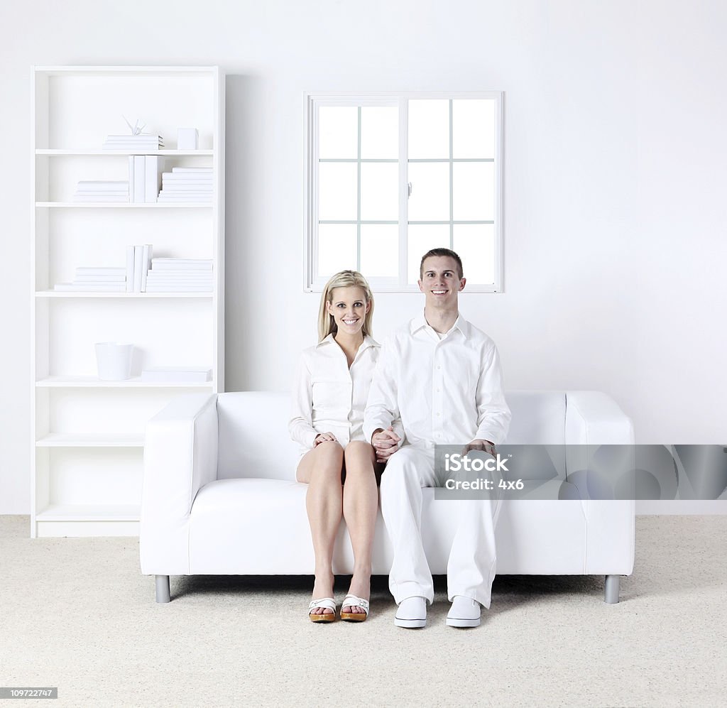 Para siedzi na kanapie, - Zbiór zdjęć royalty-free (20-29 lat)