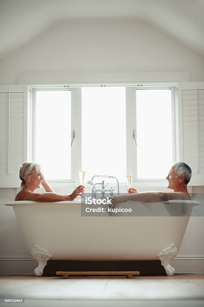 Verres de champagne toast couple romantique dans une baignoire - Photo de Baignoire libre de droits