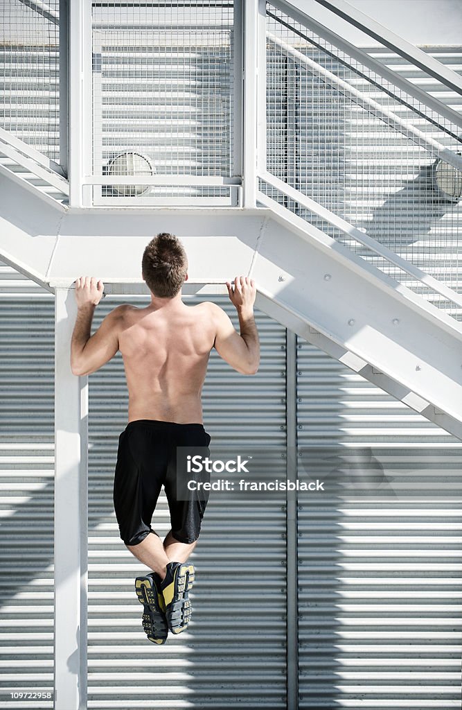 Atleta facendo un pull-up in una scena urbana con copia - Foto stock royalty-free di Trazione delle braccia