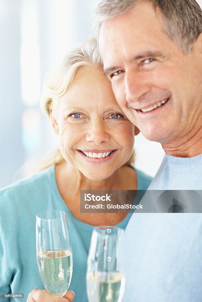 Detalhe de um feliz aposentado casal segurando copos de champanhe - Foto de stock de Terceira idade royalty-free