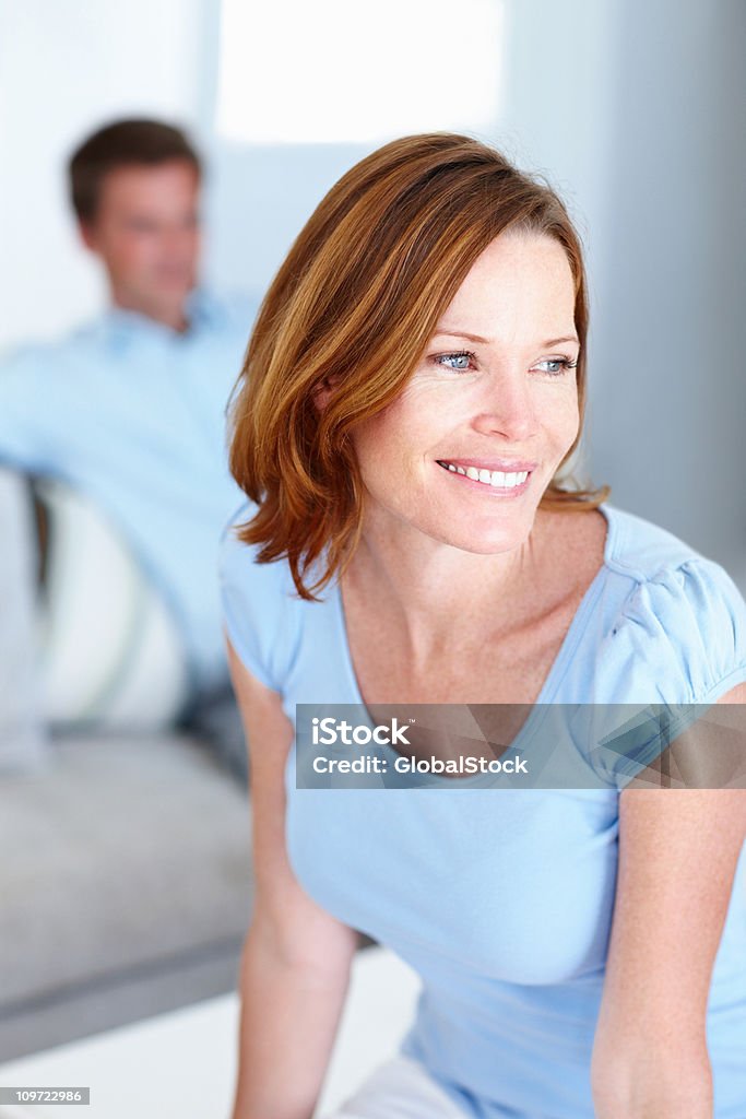 Pensive femme souriant avec mari à l'arrière - Photo de 30-34 ans libre de droits