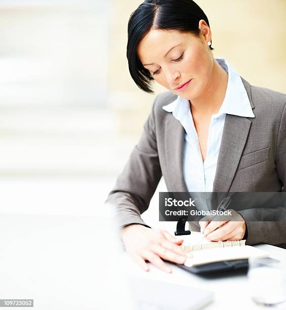 Foto de Mulher De Negócios Fazendo Uma Nota No Black Book e mais fotos de stock de 20 Anos - 20 Anos, Adulto, Agenda