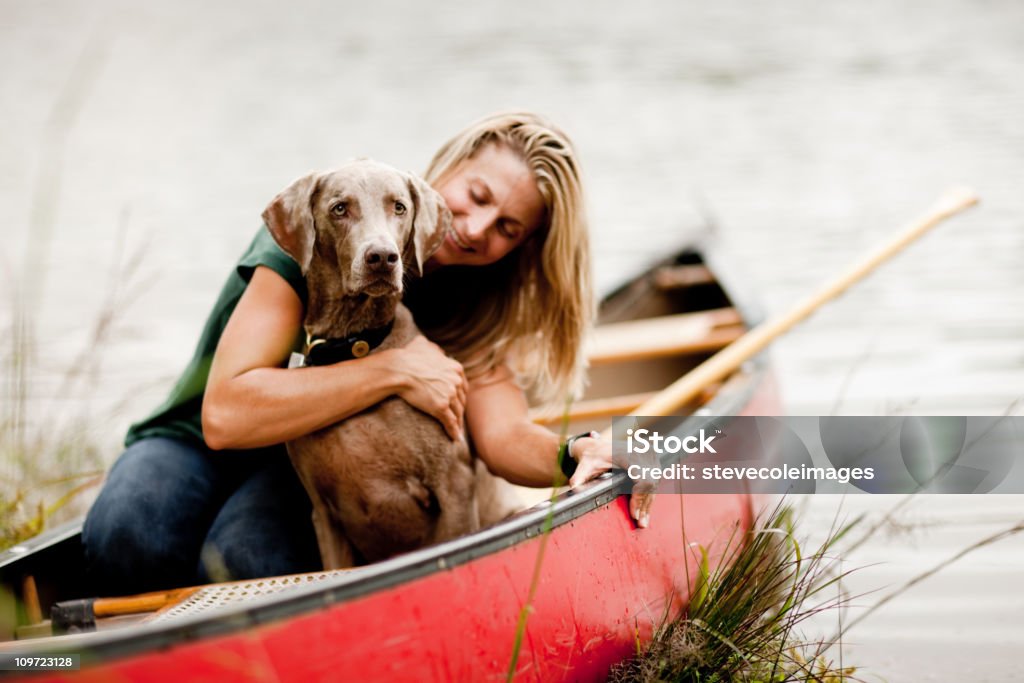 Woman Hugging Dog in a Canoe  Canoe Stock Photo