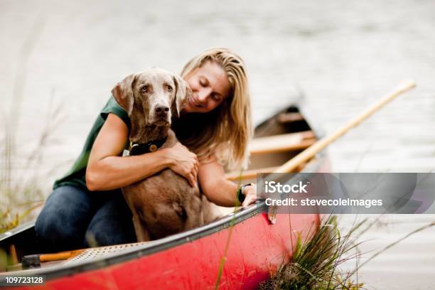 Woman Hugging Dog In A Canoe Stock Photo - Download Image Now - Canoe, Dog, Canoeing