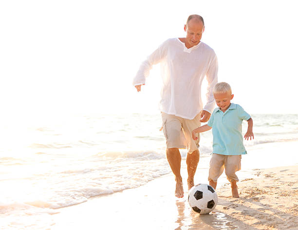 istock Father and Son playing Football on a Beach. 109723165