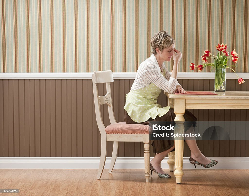 Triste ama de casa con mesa de comedor - Foto de stock de Rodapié libre de derechos