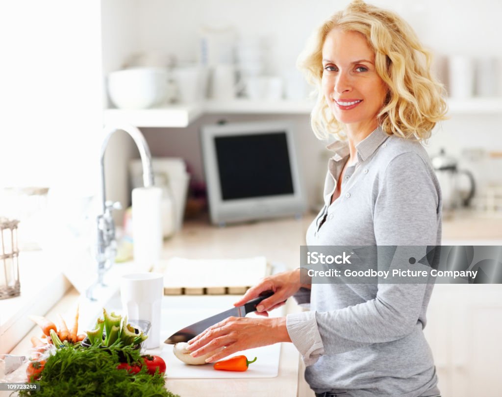 Medio de mujer verduras de corte en la cocina - Foto de stock de Mujeres libre de derechos