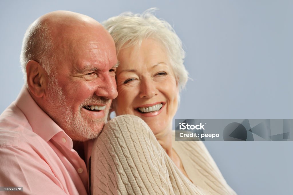 Un couple senior souriante posant pour la caméra. - Photo de Adulte libre de droits