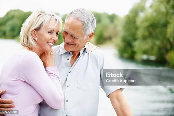 Photo libre de droit de Homme Âgé Dans Ambiance Romantique Tout En Regardant La Femme Dâge Mûr banque d'images et plus d'images libres de droit de Adulte