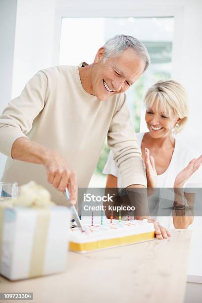 Feliz Hombre Anciano Y Mujer Madura Cortando El Pastel Foto de stock y más banco de imágenes de Cumpleaños