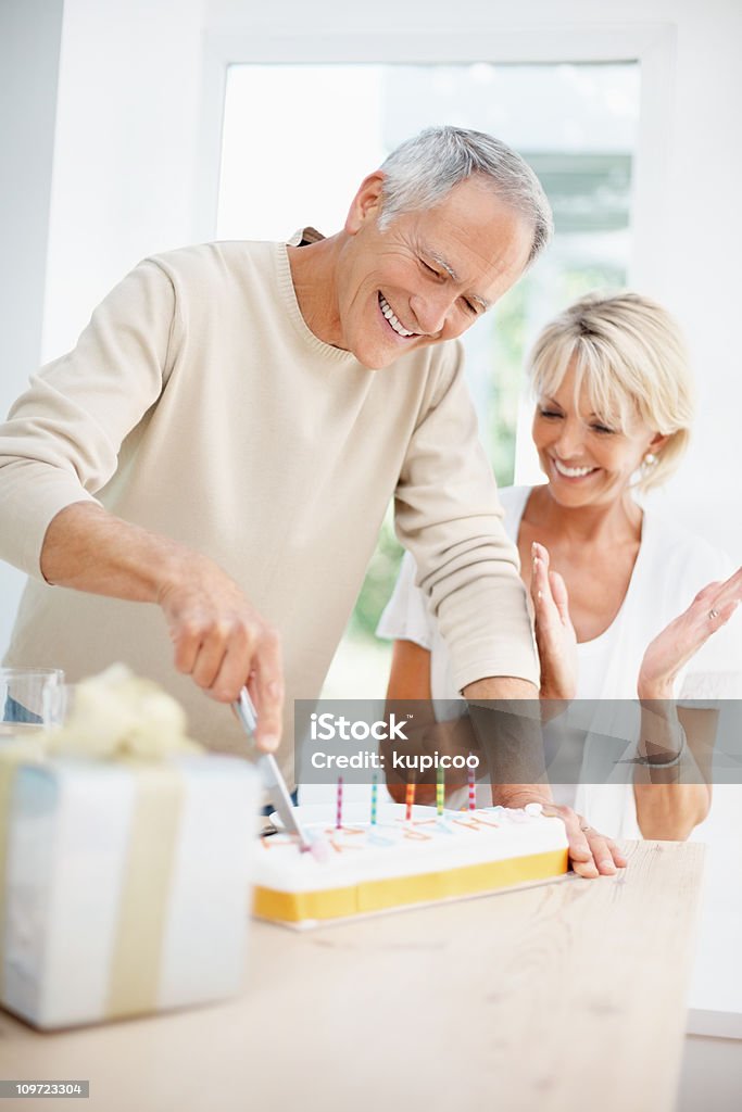 Felice uomo anziano con donna matura taglio della torta - Foto stock royalty-free di Compleanno