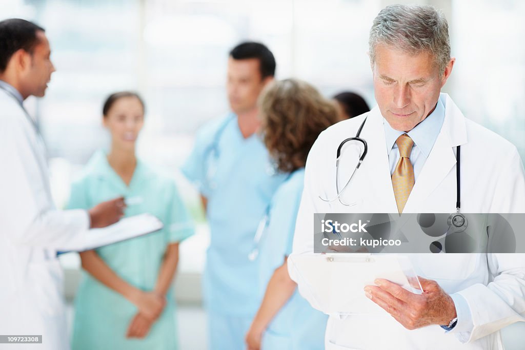 Senior médico se notar algo com sua equipe no Plano de Fundo de Borrão - Royalty-free Doutor Foto de stock
