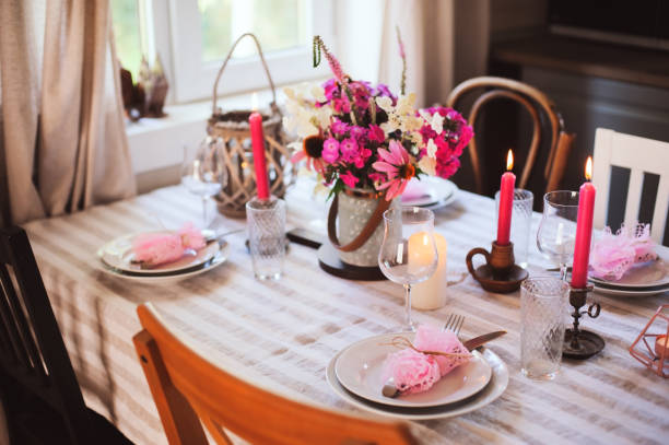 istock summer cottage kitchen decorated for festive dinner. Romantic table setting with candles and flowers in rustic style. 1097233552