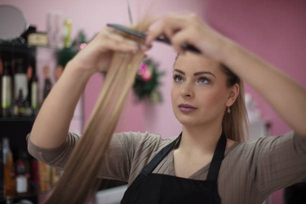 She now the best what is need your hair. Woman at the hairdresser. Close up. Hairdresser cuts hair. Focus on hands.