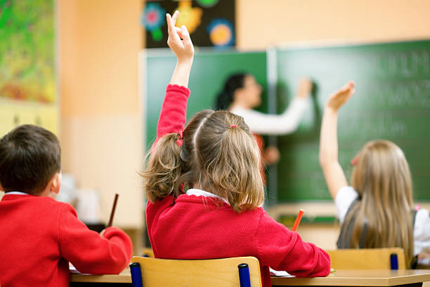 dzieci podnosząc ręce w klasie, widok z tyłu - school classroom child back to school zdjęcia i obrazy z banku zdjęć