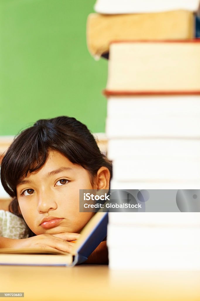 Retrato de una chica cansada con pila de libro de lectura - Foto de stock de Aburrimiento libre de derechos