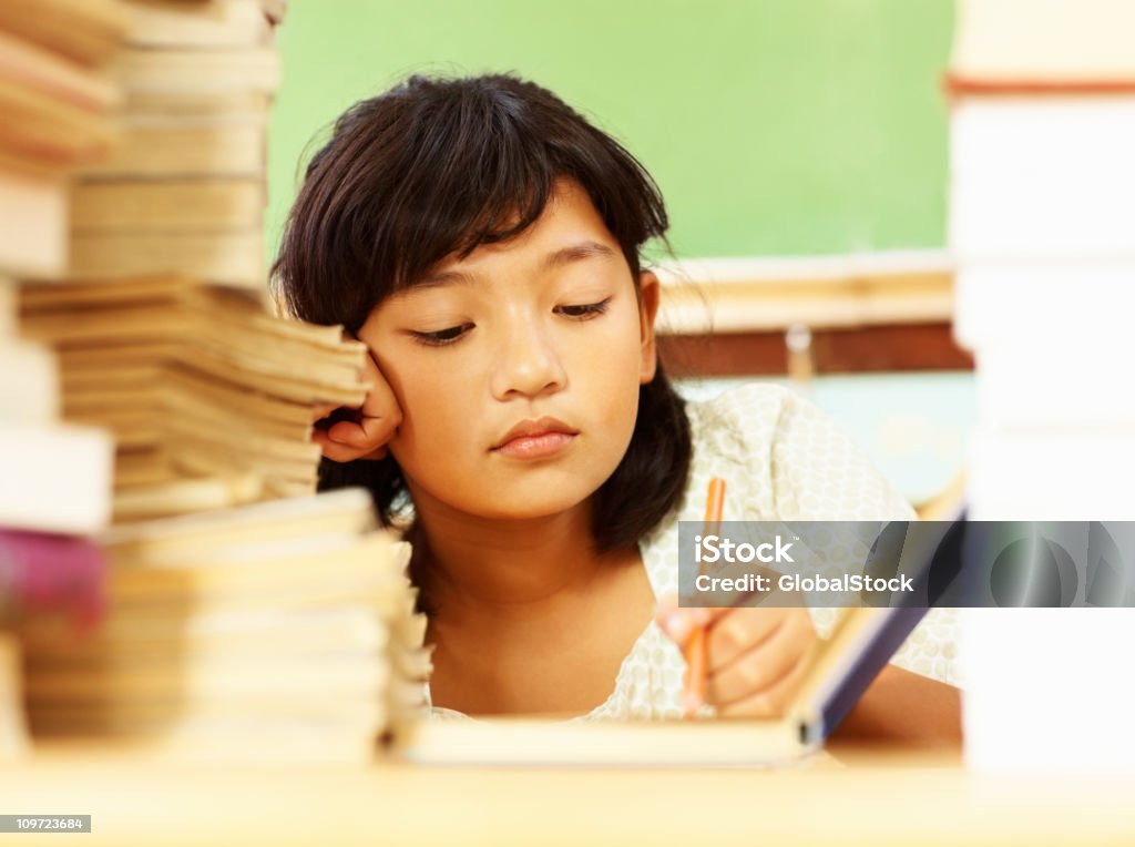Portrait d'une petite fille fatigués avec une pile de livres de lecture - Photo de Lutte - Concepts libre de droits