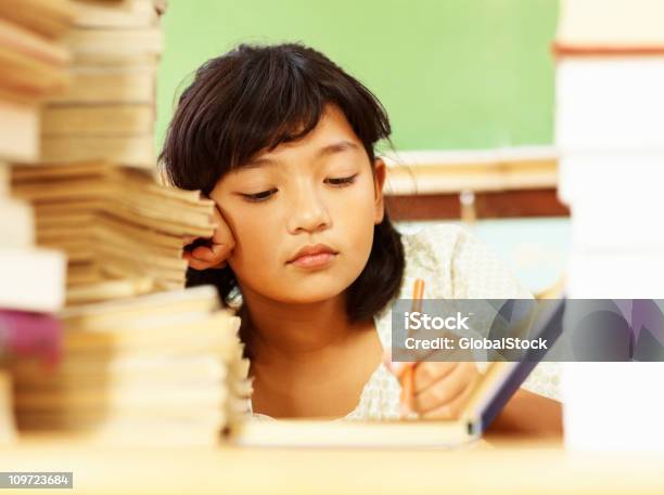 Photo libre de droit de Portrait Dune Petite Fille Fatigués Avec Une Pile De Livres De Lecture banque d'images et plus d'images libres de droit de Lutte - Concepts