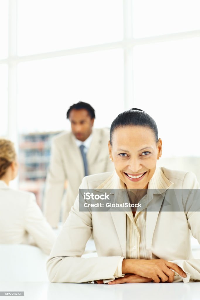 Close-up de feliz empresaria con colegas en fondo - Foto de stock de 20 a 29 años libre de derechos