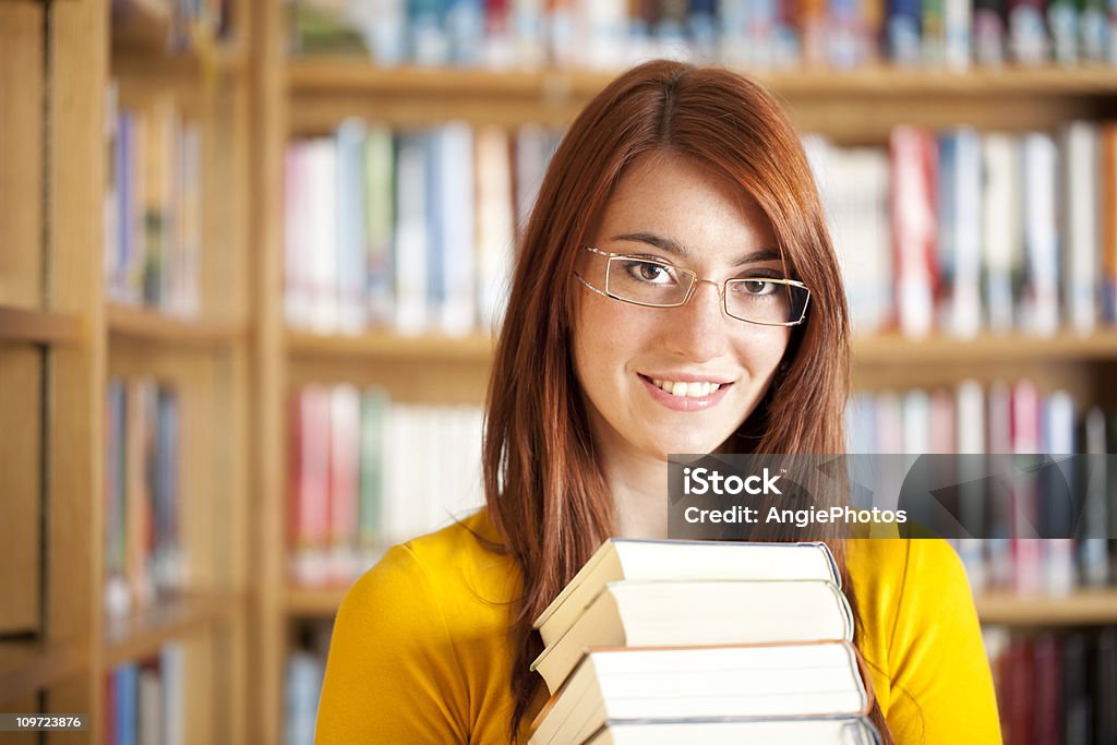 Atractiva mujer con libros de biblioteca - Foto de stock de Biblioteca libre de derechos