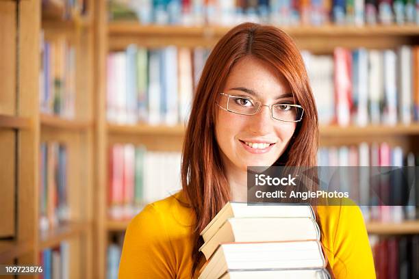 Atractiva Mujer Con Libros De Biblioteca Foto de stock y más banco de imágenes de Biblioteca - Biblioteca, Estantería de libros, Pelirrojo