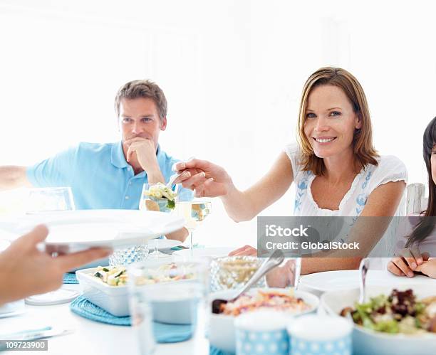 Junge Frau Die Essen Mit Der Familie Ein Mittagessen Stockfoto und mehr Bilder von Behaglich