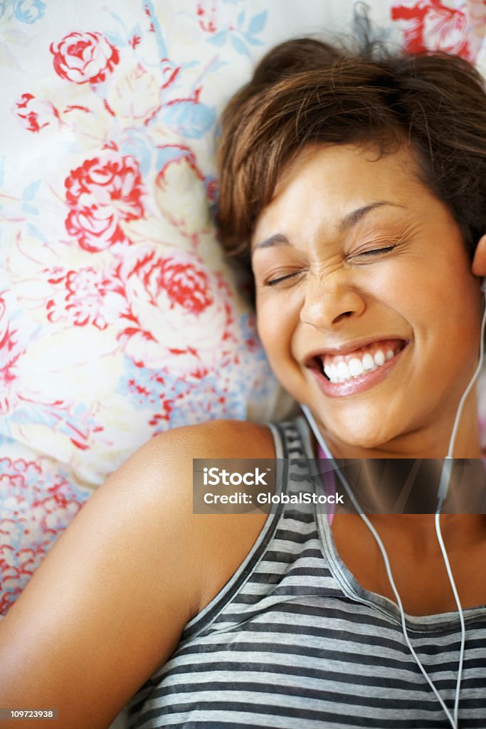 Allegro giovane ragazza godendo la musica tramite auricolari - Foto stock royalty-free di Ridere