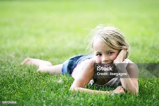 Little Girl Lying On Grass Foto de stock y más banco de imágenes de Acostado - Acostado, Aire libre, Alegre