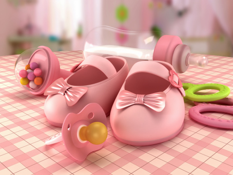 Set of diapers and pink baby accessories for baby girl lying on couch. Newborn concept