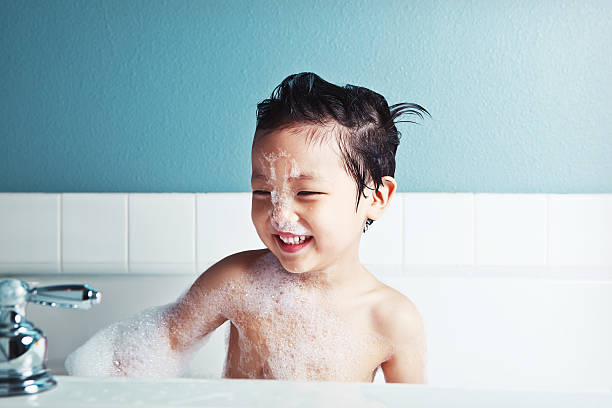 garçon asiatique prenant un bain et souriant - covered nudity photos et images de collection
