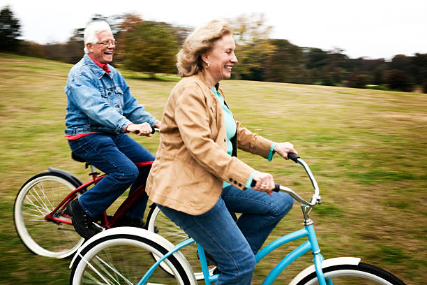 Elderly man riding a blue bicycle and smiling at camera isolated on white background