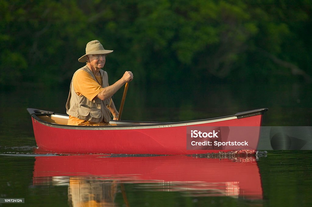 Homme Senior pagayer un canoë - Photo de Troisième âge libre de droits