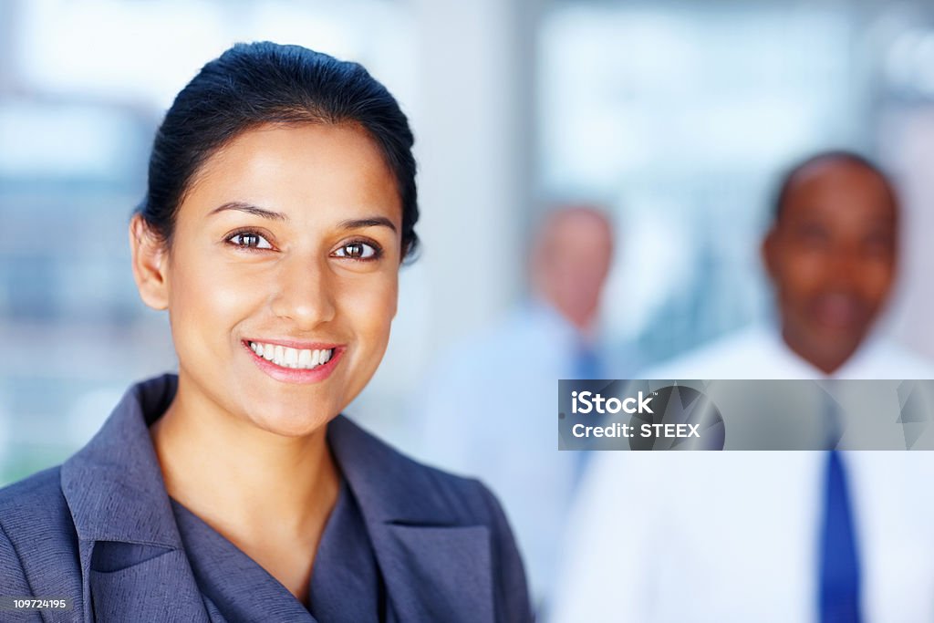 Exitosa mujer de negocios con equipo de fondo - Foto de stock de Confianza en sí mismo libre de derechos