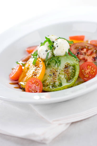 A vibrant Caprese salad featuring a variety of flavorful tomatoes paired with mozzarella cheese and drizzled with olive oil. This salad is full of summer’s fresh and lively spirit.