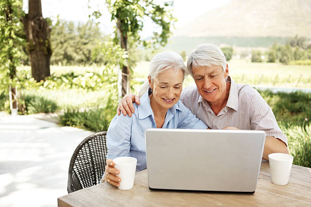 istock Happy retired couple using a laptop outdoors 109724581