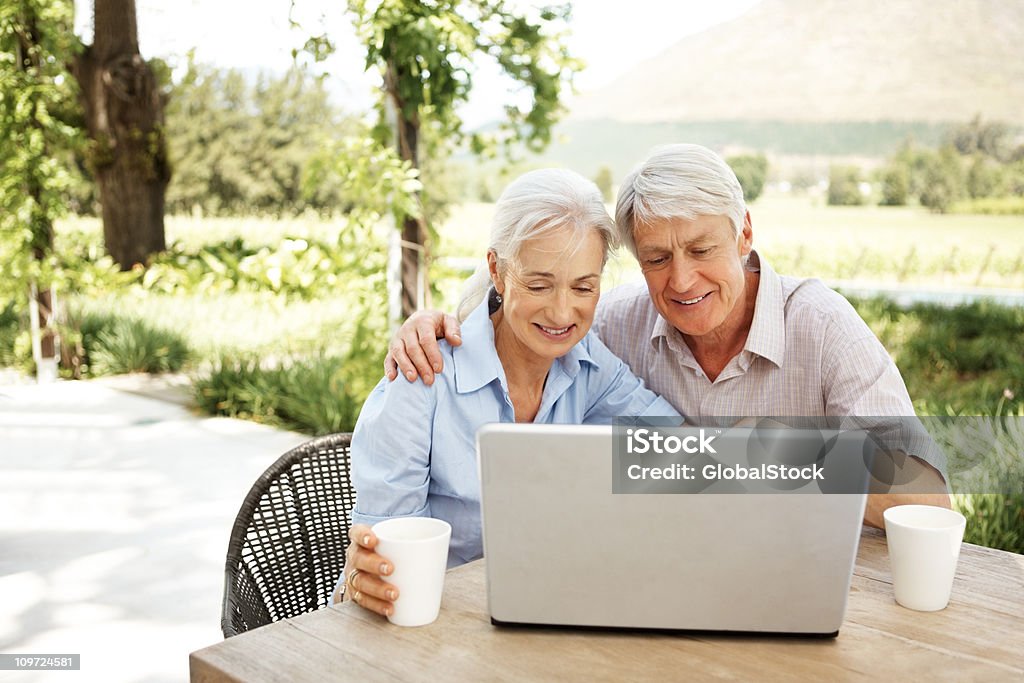 Feliz Aposentado Casal usando um laptop ao ar livre - Royalty-free Casal Foto de stock