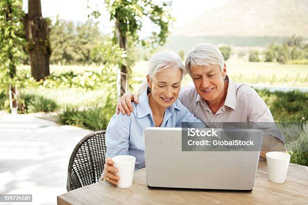 Feliz Aposentado Casal Usando Um Laptop Ao Ar Livre - Fotografias de stock e mais imagens de Casal