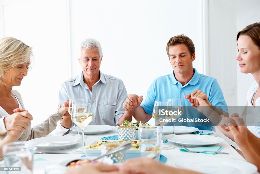 Familia rezar conjuntamente antes de las comidas - Foto de stock de Familia libre de derechos