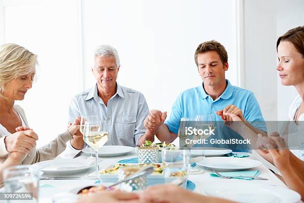 Familia Rezar Conjuntamente Antes De Las Comidas Foto de stock y más banco de imágenes de Familia - Familia, 50-54 años, Cena