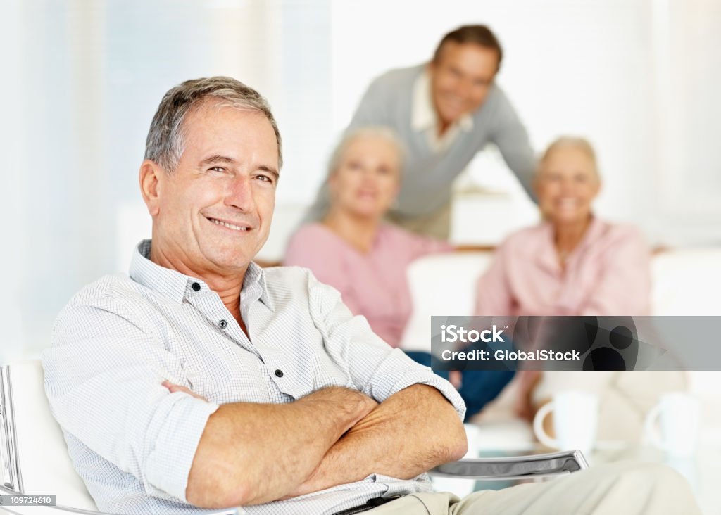 Sicurezza uomo anziano sorridente con gli amici in background - Foto stock royalty-free di Amicizia